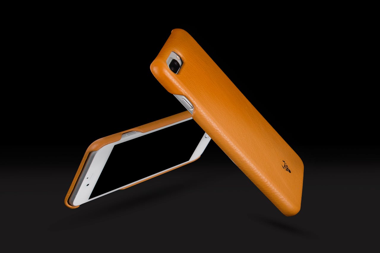 hero-img-02 Dynamic image of sleek orange phone cases in a minimalist style, emphasizing modern technology and design.
